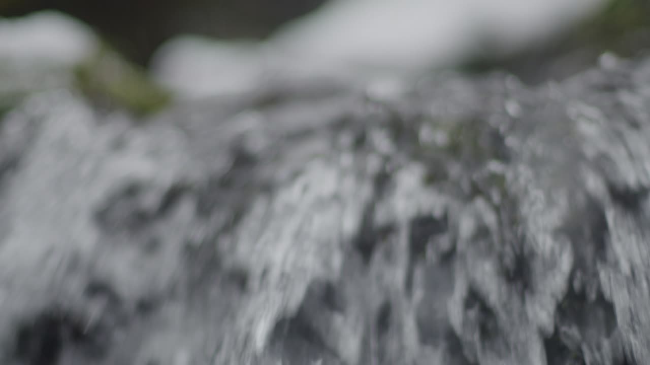 Clean water flowing over the edge of a waterfall close up