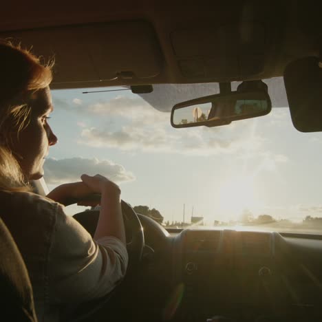 Middle-aged-female-driver-drives-car-in-setting-sun