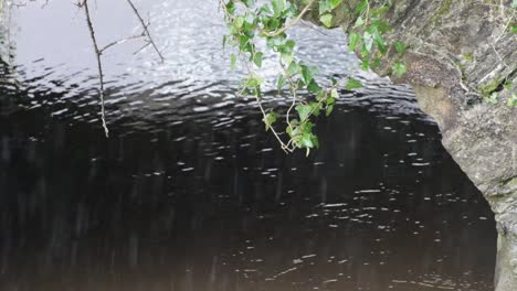 Lloviendo-Sobre-Aguas-Turbias-Bajo-El-Puente-De-Piedra-Con-Encabezado-Verde