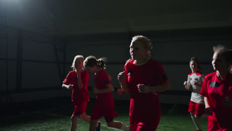 young girls soccer team running during indoor practice.