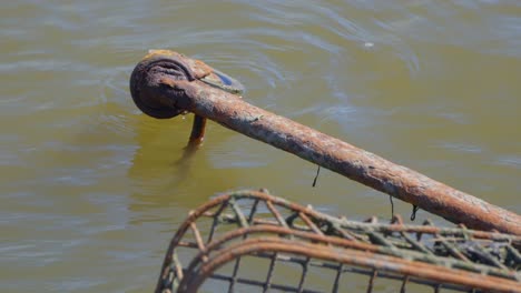 shopping cart wheel close up, partially submerged in dirty water, old and rusted