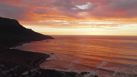 beautiful seascape view with orange sunset at bakoven beach, cape town in south africa