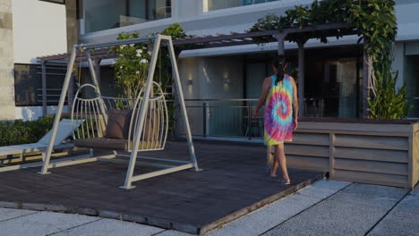 mujer asiática caminando en la terraza al aire libre a la luz del atardecer en un hotel de lujo en uluwatu, bali, indonesia