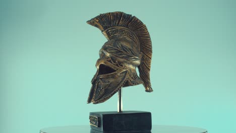 un primer plano giratorio de un casco de bronce de metal griego antiguo guerrero espartano, con formas y formas, iluminación de estudio, cámara lenta, video de 4k