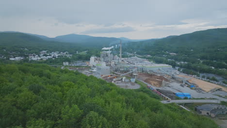 Wide-Aerial-Shot-of-Paper-Mill-With-Lush-Foliage-in-Foreground,-Rumford-Maine