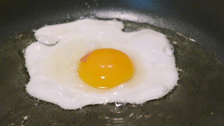 Top View of Sunny Side Up Egg Frying in Hot Oil in Pan. Cooking Protein Rich Breakfast Healthy Food