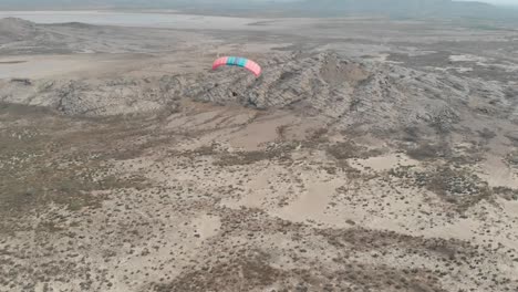 Aerial-View-Of-Motorised-Paraglider-Flying-Over-Arid-Landscape-In-Karachi