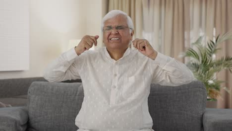 Sleepy-and-tired-Indian-old-man-yawning-and-stretching-body