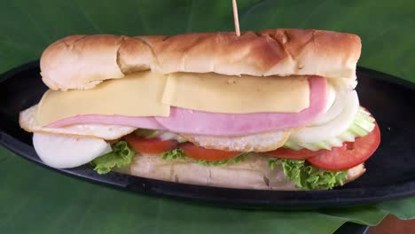 sándwich de jamón y queso con vegetales saludables envueltos en un rollo de descanso