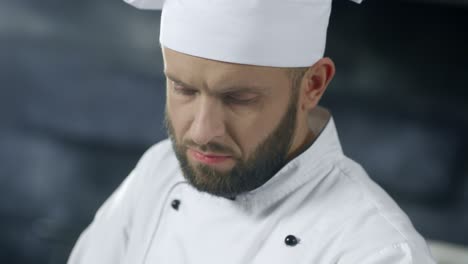 chef man working at professional kitchen. close up chef face cooking food