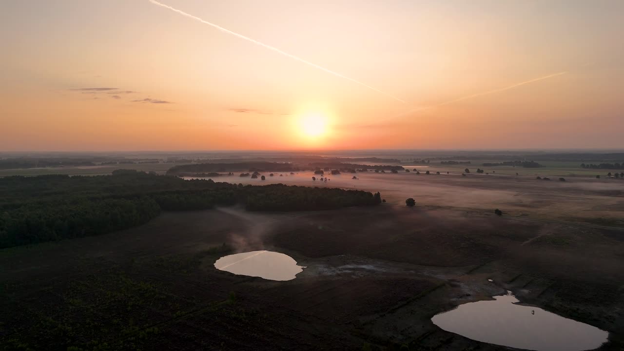 Aerial View of Misty Landscape at Sunrise with Lake and Forest