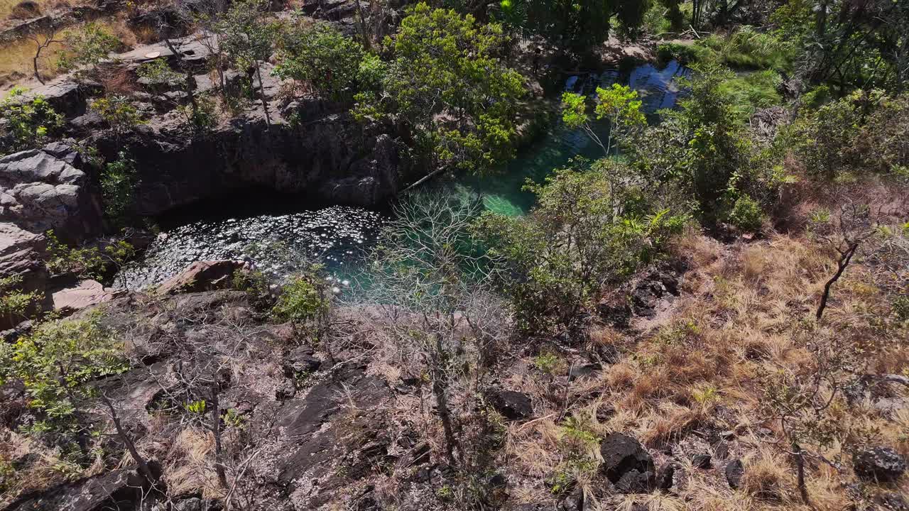 La visuale a volo di drone del complesso Águas Lindas a Chapada dos Veadeiros mostra pozze color smeraldo cristalline scavate nel terreno roccioso e circondate dalla vegetazione nativa del cerrado