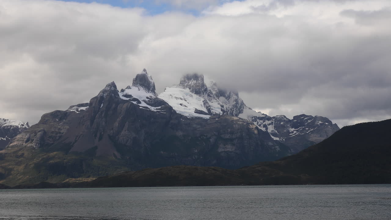 Nuvole pesanti coprono la Catena del Darwin nei fiordi patagonici, Terra del Fuoco, Cile, Sud America.