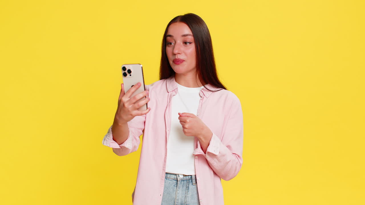 Woman energetically waving hand during video call on smartphone cheerful expressive conversation