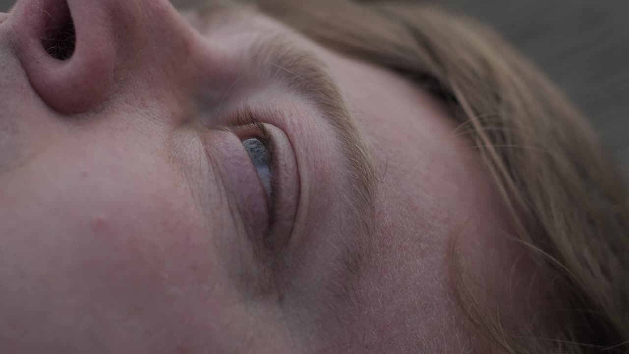 joven yace solo en la pasarela de madera y mirando fijamente al lago. pensando en la vida. atmósfera pacífica en la naturaleza. disfrutando del aire fresco. vista trasera.