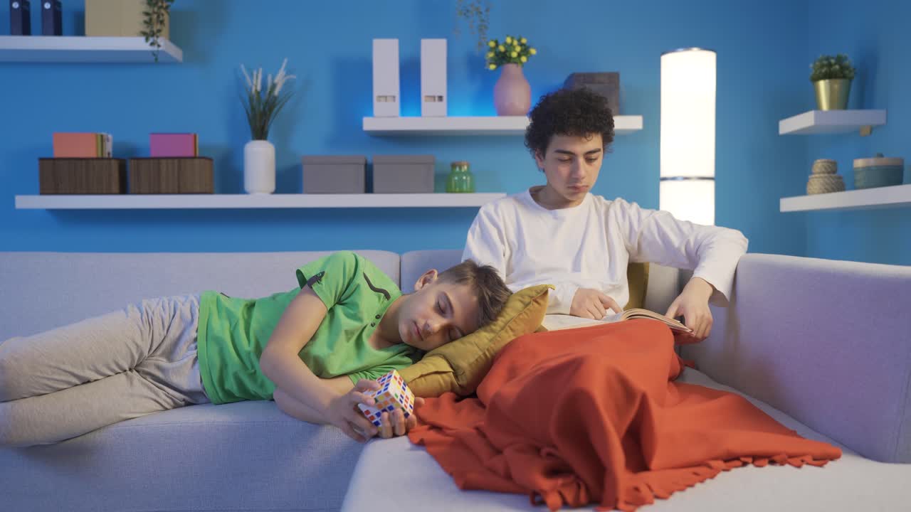 소파에서 잠들어 있는 남동생의 머리를  ⁇ 는 어른 아이.