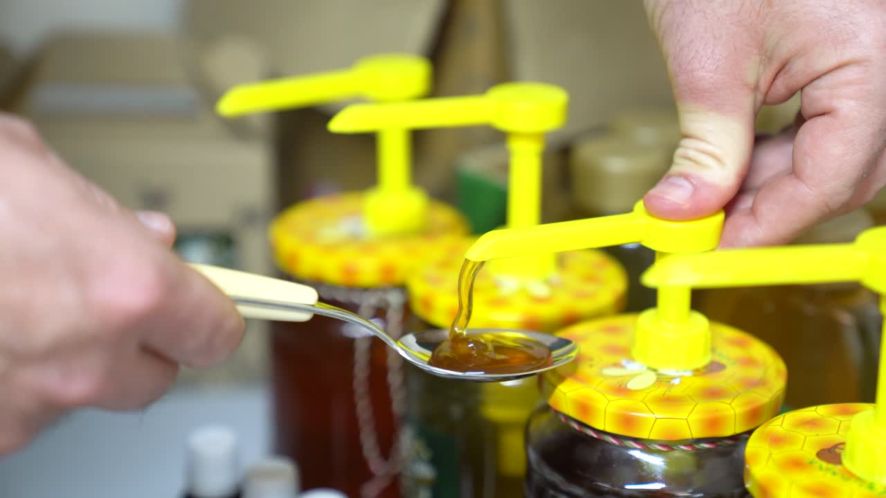 Person Pumping Organic And Fresh Honey Bee On The Teaspoon. - closeup shot