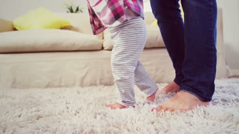 dad assisting baby to walk