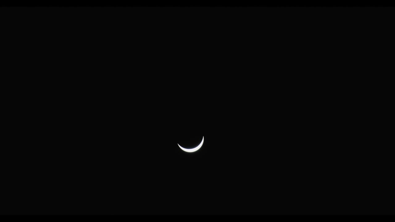 Partielle Sonnenfinsternis nachts aufgenommen, wobei die Sichelform am dunklen Himmel leuchtet