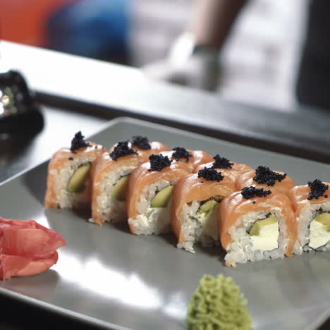 professional chef in a commercial kitchen in a restaurant or hotel is serving sushi rolls sqare video