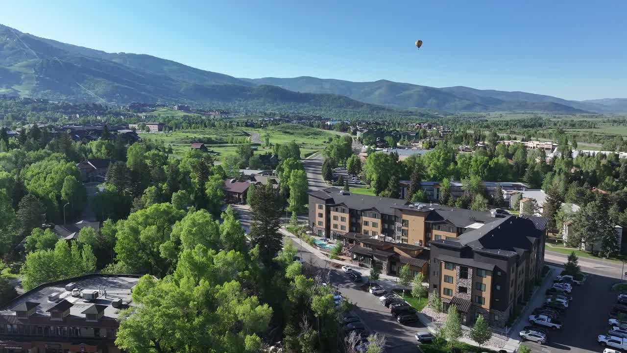 A drone drifts over Steamboat Springs Colorado in the early morning of June1 2025 with a hot air balloon in the distance.