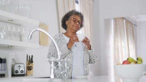 senior mixed race woman enjoying drinking tea. social distancing and self isolation in quarantine