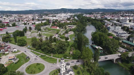 aerial view of banja luka city flying over orthodox church beside river vrbas