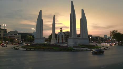 Cars-drive-around-traffic-circle-at-sunset