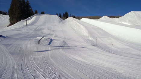 x games half pipe ski snowboarding terrain park rail fresh groomed bluebird sunny morning bottom of buttermilk opening chairlifts aspen colorado slider movement left