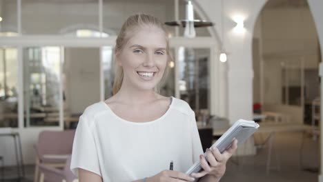 pretty fair haired young woman holding documents