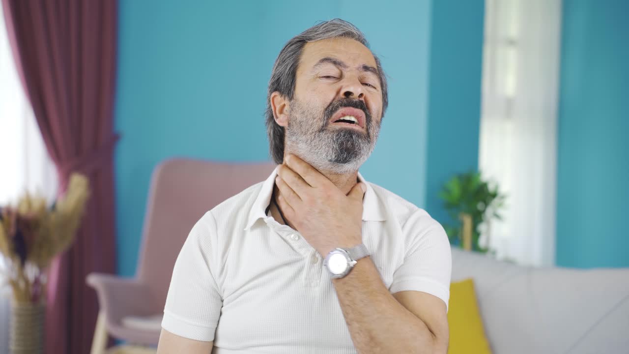 hombre de mediana edad que sufre de dolor de garganta.