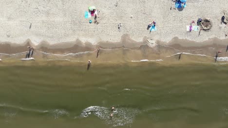 Wijk-aan-Zee-shoreline-with-people-enjoying-the-beach-in-North-Holland,-the-Netherlands---Rocket-Bird's-eye-view-Aerial-shot