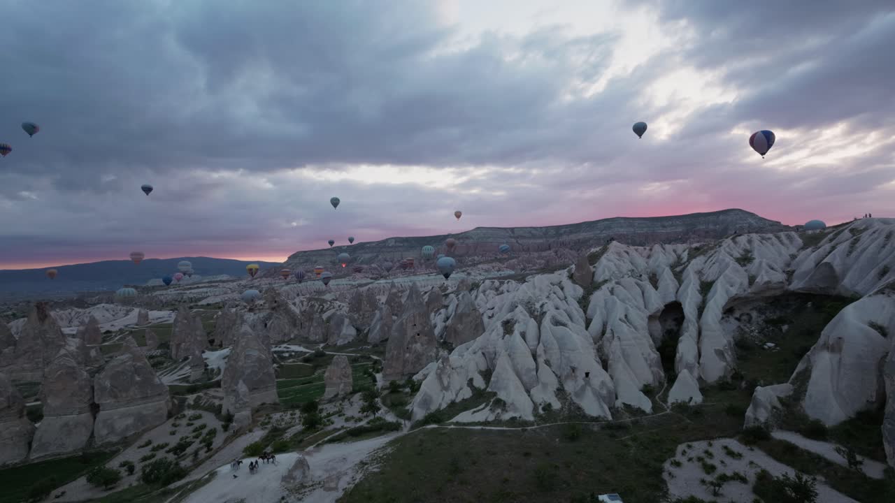 torres de valle erosionadas por el volcán de capadocia pavo con globos de aire caliente a través del cielo de la madrugada del amanecer