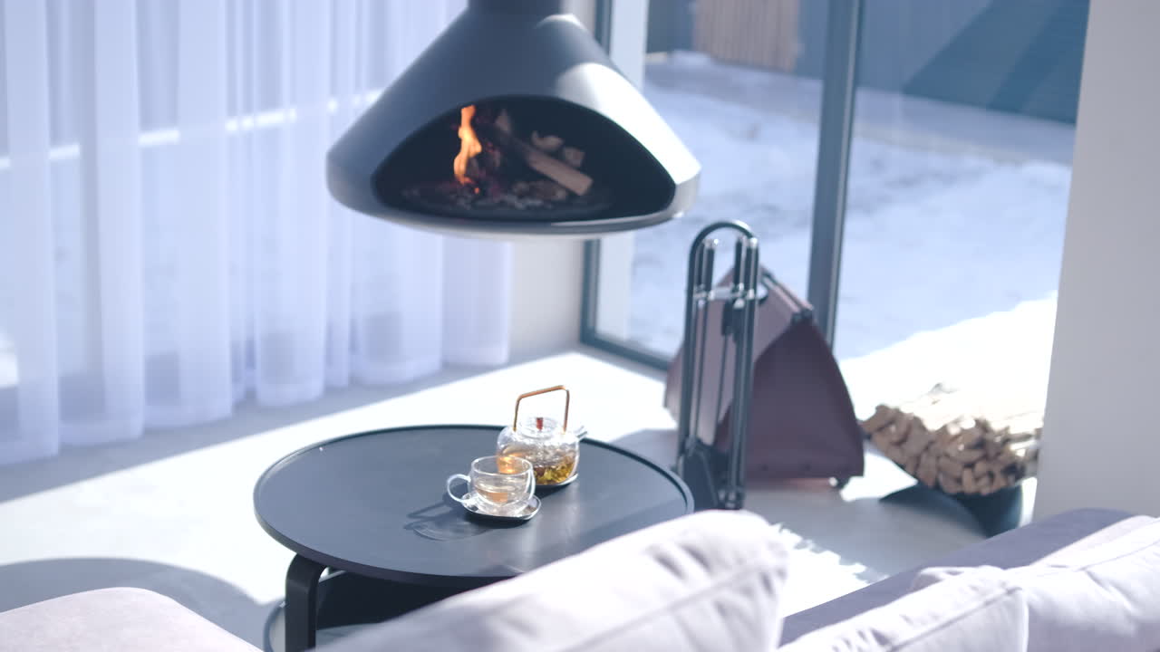 Moderne Woonkamer met Hangende Open Haard en Thee op een Winterdag