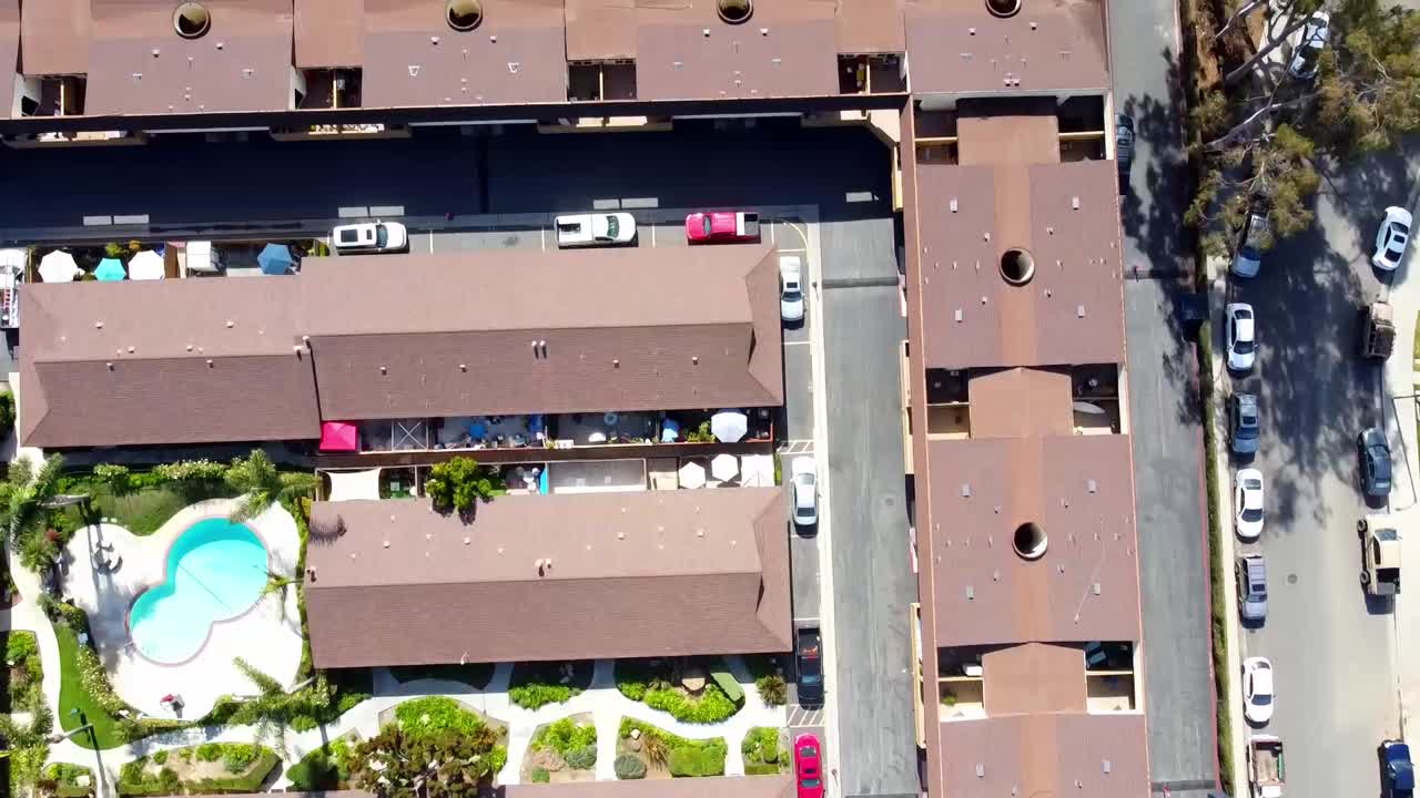 disparo de un dron alto sobre un complejo de edificios de apartamentos con coches conduciendo por la carretera