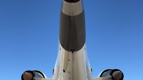 vista exterior de la cola y la parte trasera de un avión de reacción de tamaño medio blanco con un cielo azul profundo