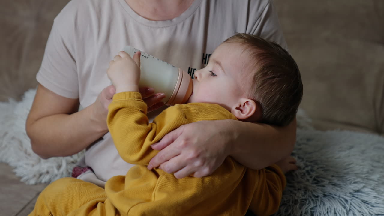 madre alimentando al bebé con un biberón