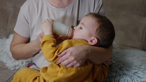 mother feeding baby with a bottle