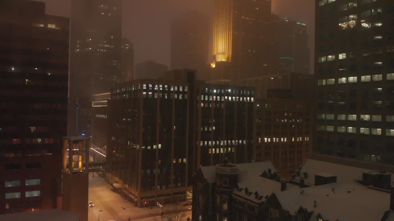 Edifici di notte durante una bufera di neve nel centro città.
