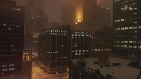 buildings at night during a snowstorm in downtown