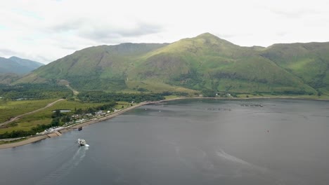 Corran-ferry-boat-on-lake-and-Sgurr-Dhomhnuill-mountain-in-background,-Scotland