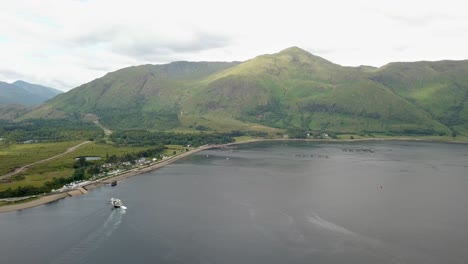 transbordador corran en el lago y la montaña sgurr dhomhnuill en el fondo, escocia