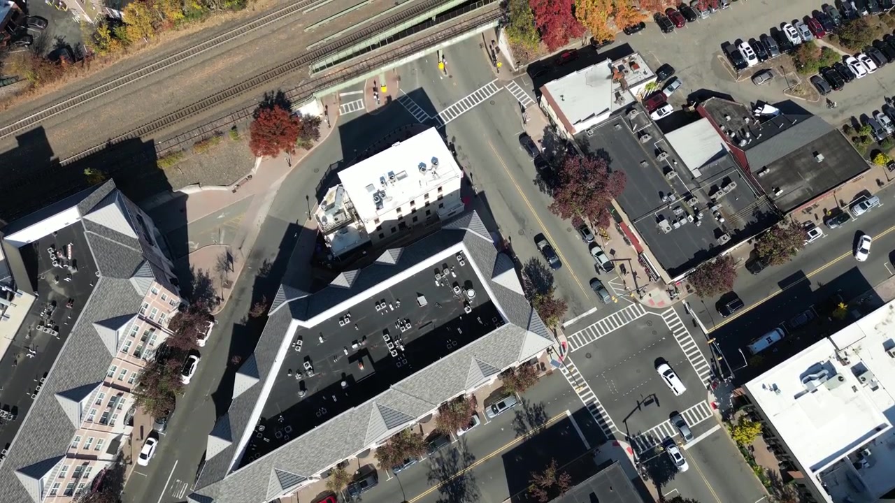 Aerial Reveal of Autumn Town Streets and Residential Blocks. The composition maintains a clear view of the principal subject and surrounding environment throughout the clip.