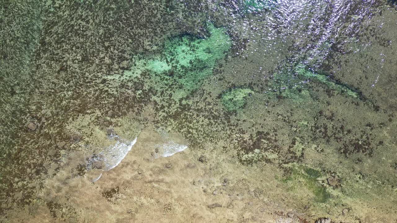 Shallow Clear Water Over Brown Pebble Sand Shore In Virac, Catanduanes - aerial top down