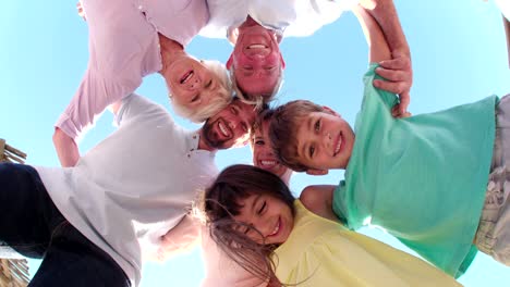 tres generaciones de la familia de pie en un círculo sonriendo