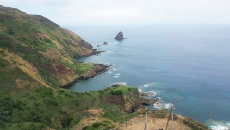 green seaside hills and open ocean by santa maria island, azores, forward aerial