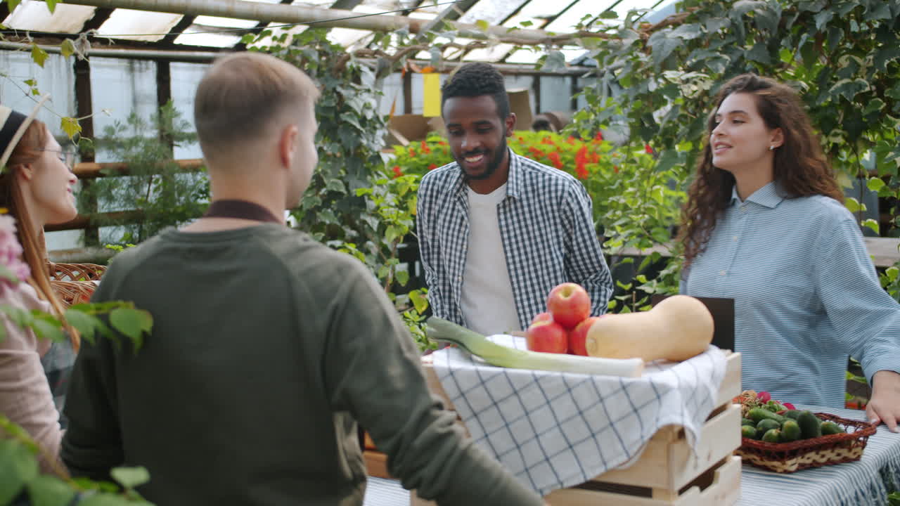 People shopping at a farmers market in a greenhouse
