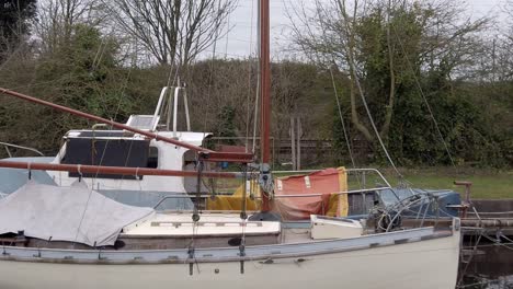 Small-sailboats-moored-on-narrow-rural-countryside-river-marina
