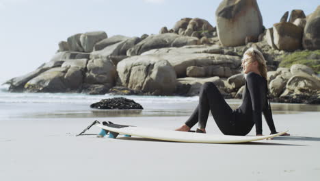Woman Surfer Relaxing on Beach with Surfboard