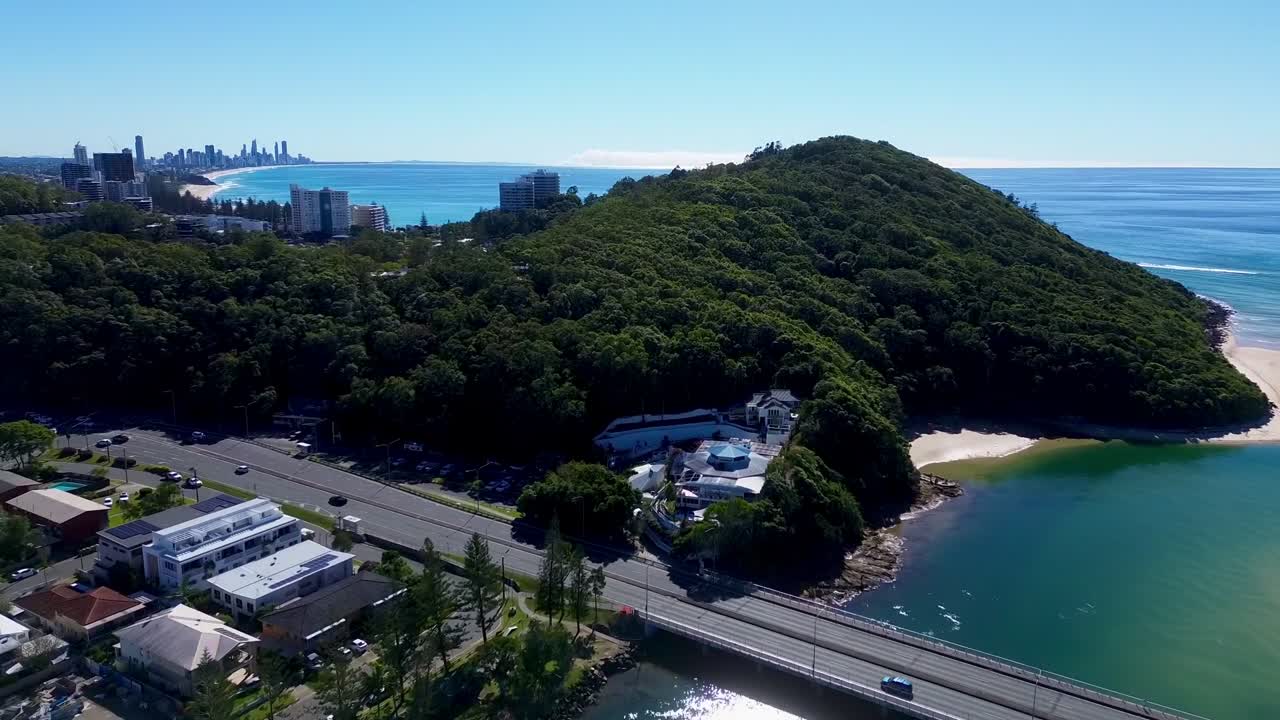 Sunning drone video of Burleigh Head National Park with Gold Coast Skyline as background